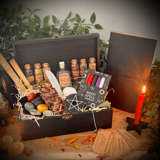 witches starter kit, black salt, crystal pendulum, candle holder, spell candles, element set, candles, glass vials of herbs, parchment sheet, sage smudge stick